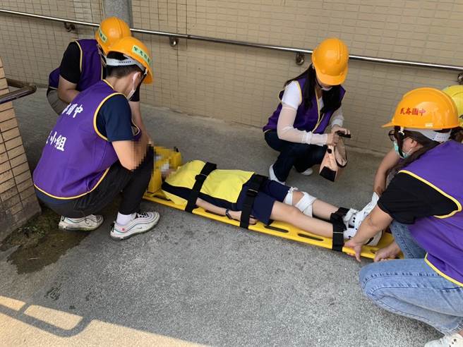 ▲防灾现场模拟有女同学出现骨折无法行动之状况，应变小组出动担架协助送同学就医。（徐佑升摄）