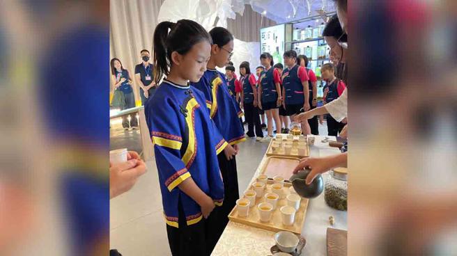 由专业茶席师冲泡六龟山茶，并由美浓国小学生奉茶给现场民眾。（图／高雄市政府客家事务委员会）