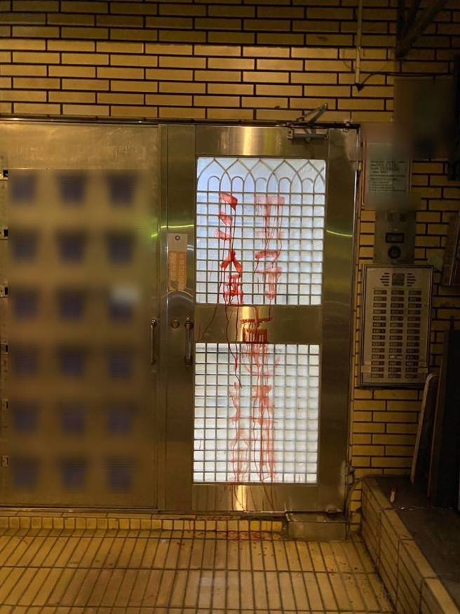 台北市大安区建国南路一段某社区大门遭不明人士泼漆并张贴「全家死光光」、「欠债还钱」恐吓字条。（图／警方提供）