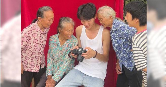 大陆一名部落客（中）协助村庄的14名老人照相。（图／翻摄自微博／央视网）