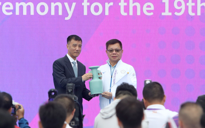 杭州亚运中华队22日与与汶莱、柬埔寨、北韩、巴勒斯坦与泰国一起升旗，之后由总领队蔡家福代表致赠纪念品。（郑任南摄）