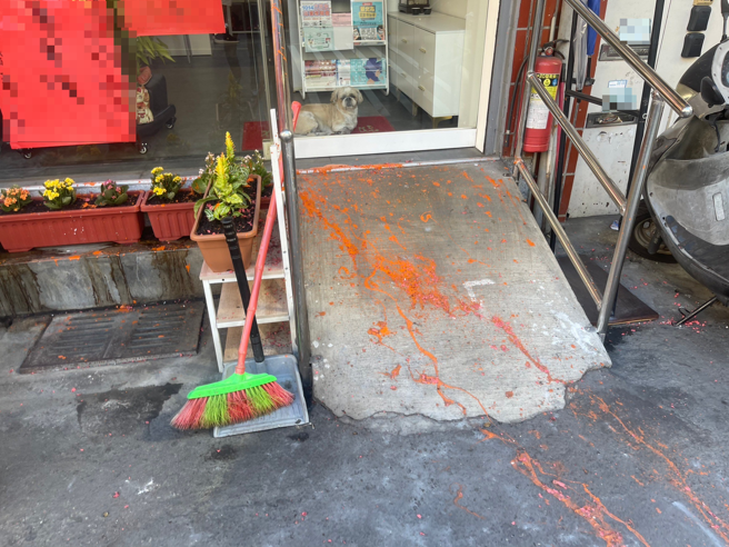 新北市芦洲区仁爱街一处店面，今（22日）早上7时许被发现铁卷门上遭人毁损、泼红漆，根据照片所显示可见红漆满地遍布，景象骇人。（照片 / 民眾提供）