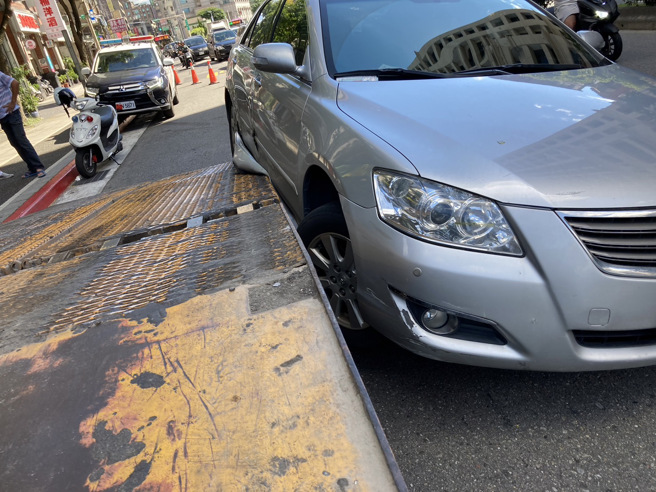 自小客不明原因撞上停在路边的曳引车，车身倾斜30度卡在曳引车后方，动弹不得。（图／警方提供）