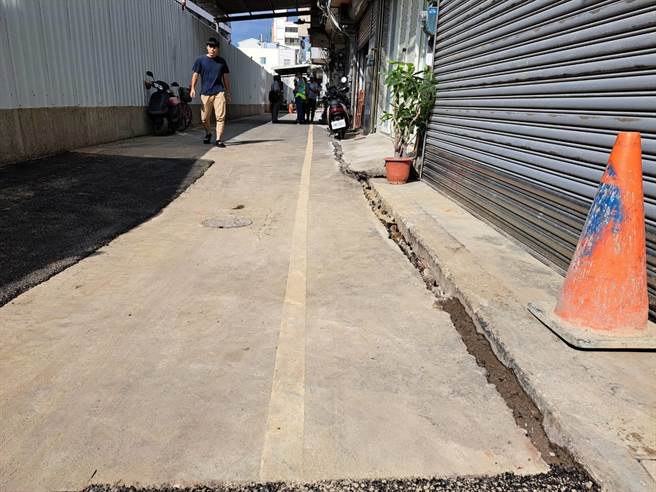 新竹市和平路20巷建案旁道路21日发生下陷，造成周边居民人心惶惶。（王惠慧摄）