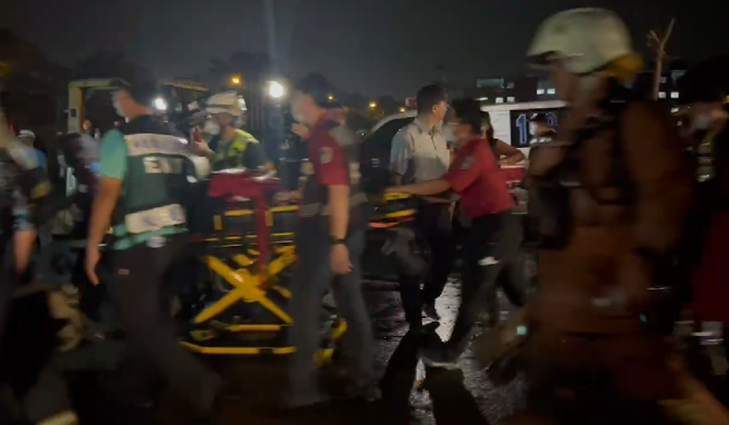 屏东明扬国际爆炸不断「火势扩大延烧」，警消暂撤离侧门以外。(林和生翻摄)