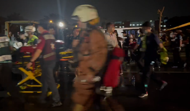 屏东明扬国际爆炸不断「火势扩大延烧」，警消暂撤离侧门以外。(林和生翻摄)