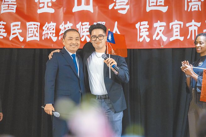 国民党总统参选人侯友宜访旧金山，20日侨宴上出现1名神秘嘉宾，是1997年南非武官遭挟持事件中，被时任北市刑大大队长侯友宜救出的小男婴查克，今年26岁的查克手持中华民国国旗，感谢侯救命之恩，2人热情拥抱。（侯友宜办公室提供）