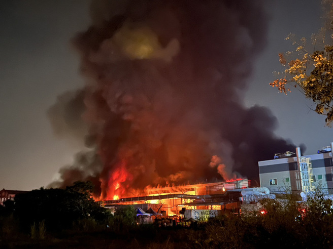 屏东加工出口区高尔夫球代理厂「明扬国际」22日大火，厂房全陷火海，截至深夜仍在燃烧，造成1消防员死亡。(林和生摄)