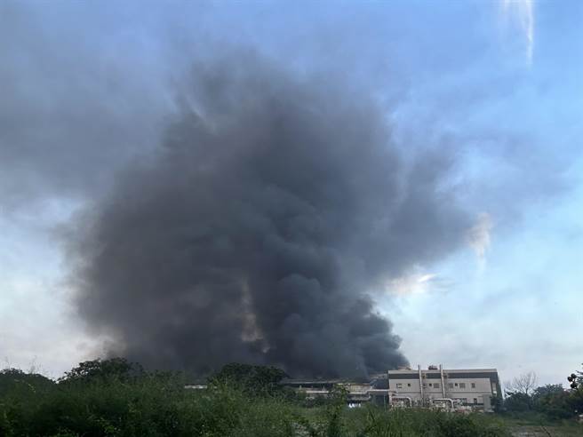 23日清晨现场依旧浓烟密布、直窜天际，清晨5时许甚至冒出阵阵火光。（谢佳潾摄）