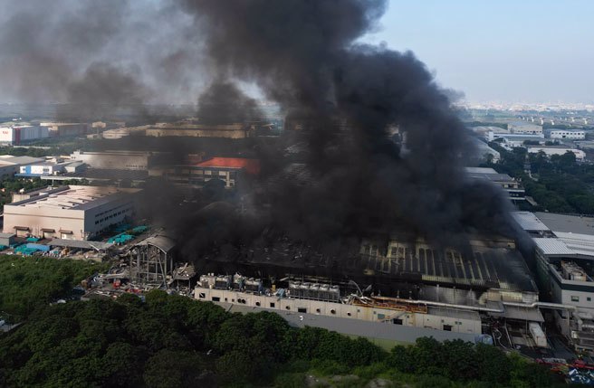 屏东科技产业园区明扬高尔夫球厂22日发生爆炸，火场持续闷烧，清晨依然冒出浓烟直冲天际。（黄子明摄）