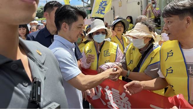 台北市长蒋万安在参拜完社子岛坤天亭后，也与社子岛开发派民眾互动，握手、拍照来者不拒。（丁上程摄）