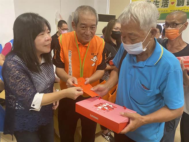 仕招基金会课长周哲仁亲自将500元红包与物资发给每位街友，领到红包及物资的街友连声道谢。（高钧麟摄）