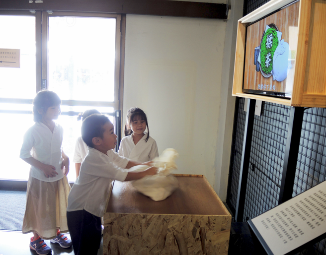 小朋友在新北市坪林茶业博物馆「晓茶塾」展览中透过数位科技体验揉茶过程。(图/新北市政府文化局提供)