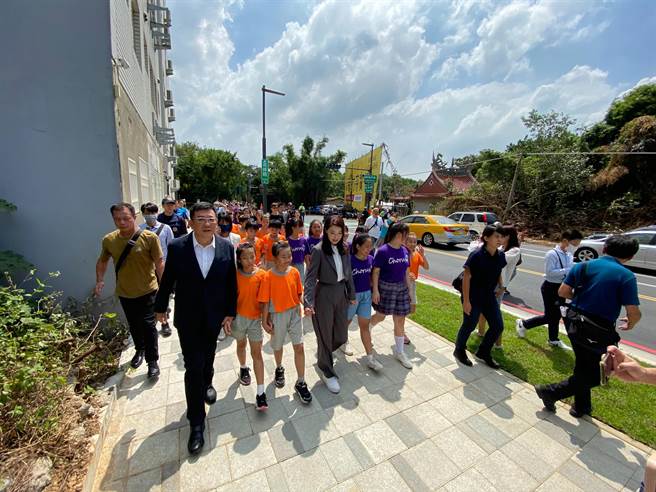 新竹市通往竹科的高峰路拓宽工程25日完工通行，市长高虹安（左四）今天与议长许修睿（左一）特别牵着孩子们一同体验宽广又安全的人行道。（陈育贤摄）