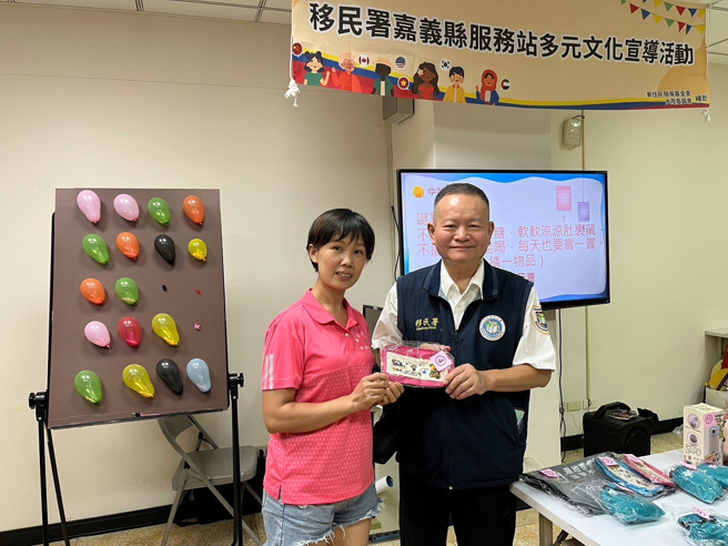 嘉义县服务站林炳煌主任（右）颁发奖项给中秋灯谜获奖民眾。（移民署嘉义县服务站）