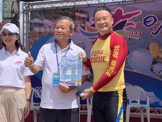 简千翔从副县长王瑞德手中拿到泳渡日月潭成功证书。（曾雪蒨摄）