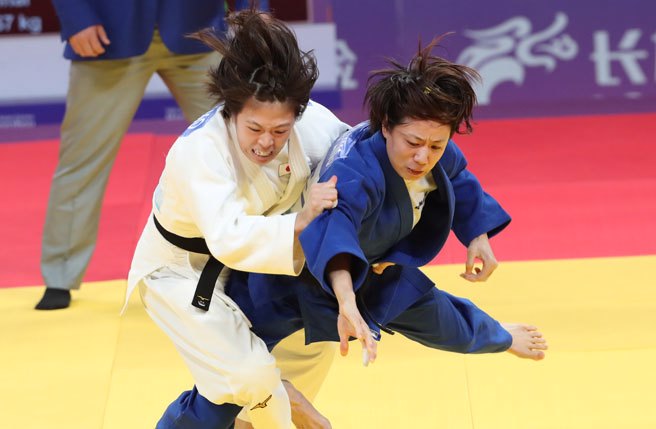 杭州亚运中华队女子柔道选手连珍羚（蓝衣）25日在女子柔道57公斤级决赛面对日本的选手，于加时赛中最后取得半胜进而获胜夺金，为中华队再添一面金牌。 （毛琬婷摄）