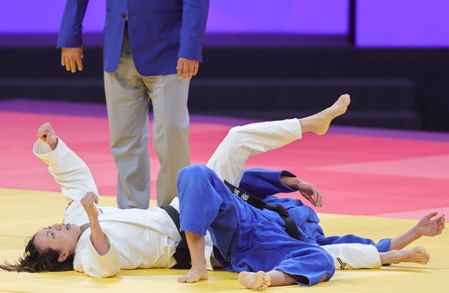 台湾「柔道女王」连珍羚（白衣）25日在杭州亚运女子57公斤级项目出赛，在4强赛击退中国选手，闯进金牌战，获胜那刻她开心振臂庆祝。(中央社)