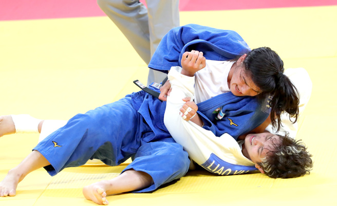 杭州亚运中华队女子柔道选手廖宇蓉（白衣）25日在女子柔道70公斤级铜牌战中败给乌兹别克的选手，无缘铜牌。 （毛琬婷摄）