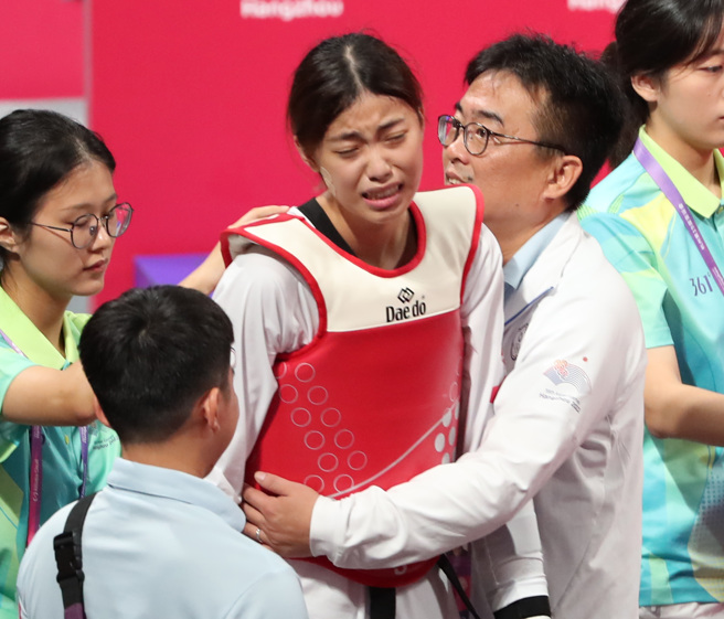 罗嘉翎（中）在金牌战不敌大陆名将骆宗诗后哭成泪人儿，教练刘聪达（右）在一旁安慰爱徒。（郑任南摄）