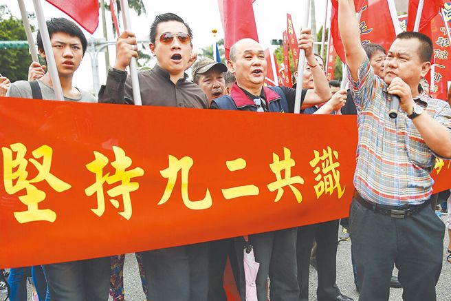 图为多个团体组织民眾在台北集会，打出「坚持九二共识、维持台海和平」等标语。（中新社）