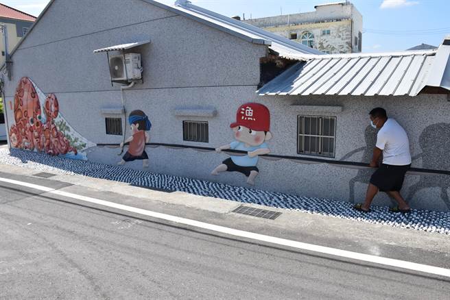 後龍鎮水尾社區最新景觀壁畫牽罟，吸引許多遊客來打卡。（謝明俊攝）