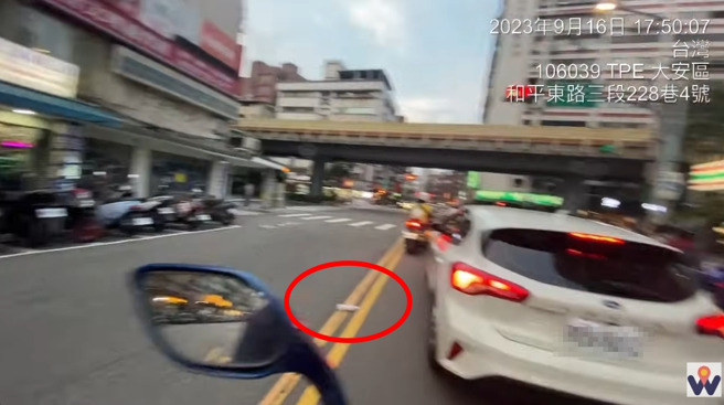 一名汽车驾驶趁等红灯，直接将垃圾丢出车外，被后面机车骑士捡起扔回车内。(图／影片截图)