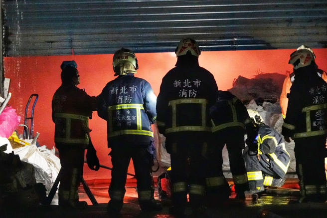 八里废五金回收场厂暗夜大火 ，大批警消忙射水灌救，铁皮厂房全面燃烧剩骨架 。(黄世麒摄)