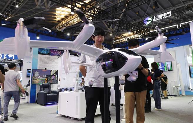 一名民眾在一架纯电动载人垂直起降飞行器模型前驻足观看。（摘自新华社）