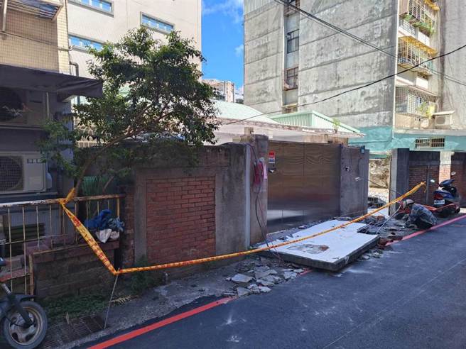 长逾1.5公尺、重达百公斤的水泥遮雨顶掉落，不偏不倚压中吴男下半身，消防人员合力抬起砖墙，协助吴男脱困。（新店警分局提供）