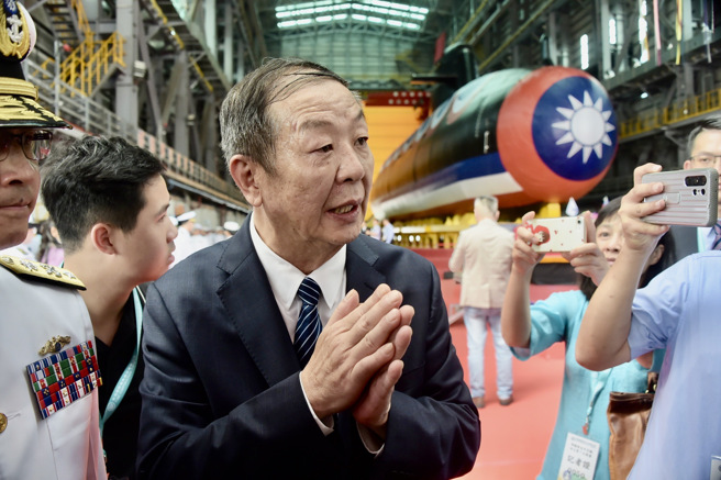 国安会谘询委员、潜舰小组召集人黄曙光（中）28日出席「潜舰国造原型舰命名暨下水典礼」，一度受到媒体包围。（陈信翰摄）