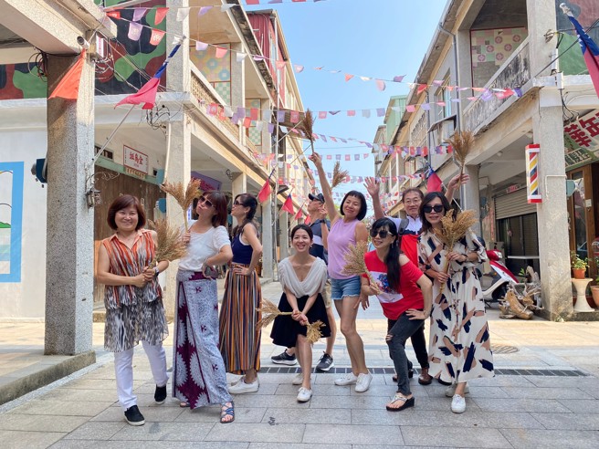 游客制作高粱扫把，为金门特有的物产纪念品。(图/信义房屋 提供)