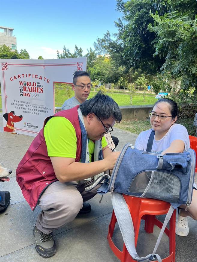 民眾于中和4号宠物公园，可将颈牌挂于狗或猫的项圈，作为施打证明。（新北市动保处提供）