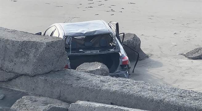 后龙镇黄姓民眾座车卡在外埔渔港南侧沙滩，轿车惨遭涨潮海水吞没，28日下午又被海上冲上岸际，车轿明显受损。（读者提供／谢明俊苗栗传真）