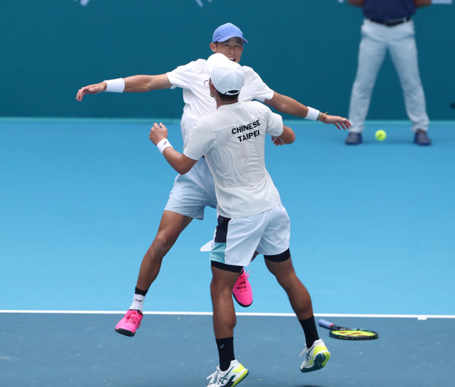 庄吉生（后）、许育修撞胸庆祝。（郑任南摄）