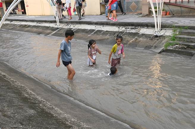 高雄美浓水圳漫旅艺术节活动29日登场，由于天气炎热，许多孩童下水戏水。（林瑞益摄）