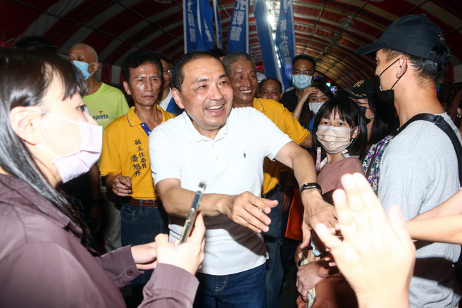 国民党总统参选人侯友宜（中）29日参加板桥深丘福德宫福德正神圣诞千秋影视歌星联欢晚会，并上香祈求国泰民安、风调雨顺。离场时一一向与会民眾握手致意。（邓博仁摄）