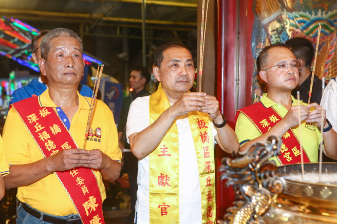 国民党总统参选人侯友宜（中）29日参加板桥深丘福德宫福德正神圣诞千秋影视歌星联欢晚会，并上香祈求国泰民安、风调雨顺。（邓博仁摄）
