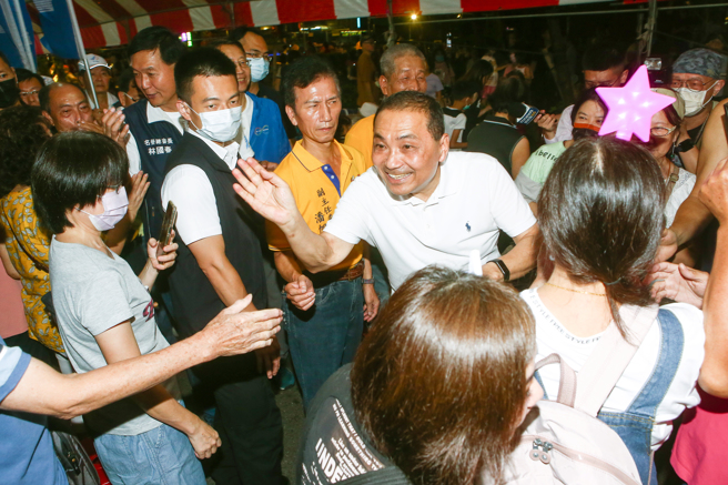 国民党总统参选人侯友宜（中）29日参加板桥深丘福德宫福德正神圣诞千秋影视歌星联欢晚会，并上香祈求国泰民安、风调雨顺。离场时一一向与会民眾握手致意。（邓博仁摄） 