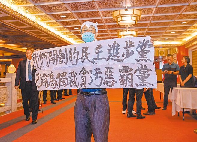 民进党创党人之一、前立委魏耀乾（中）27日在民进党37周年创党党员餐会高举「我们开创的民主进步党，已沦为独裁贪污恶霸党」。（张铠乙摄）