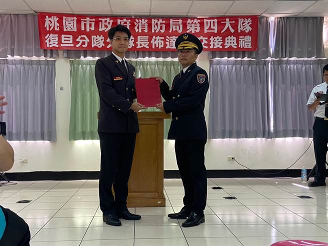 新任龙潭分队长姜麟容（右）走马上任。(桃市消防局提供／吕筱蝉桃园传真)