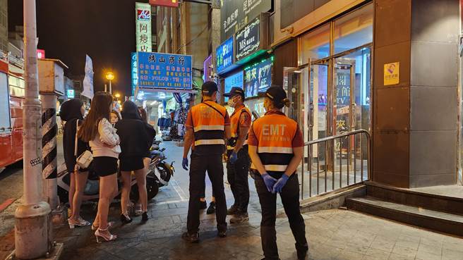 仓皇逃下楼的小姐在人行道等候状况解除，美腿如林蔚为风景。（许逸民摄）