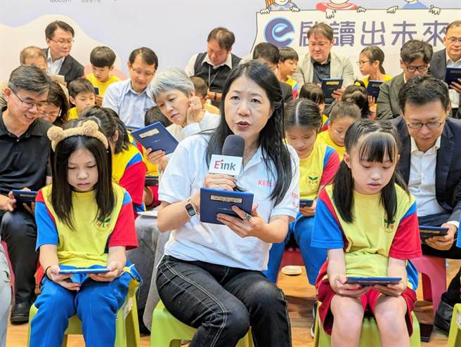 基隆市教育处长刘美兰（图中）与捐赠电子阅读器的企业代表们，共同为七堵国小的学童导读。（张志康摄）