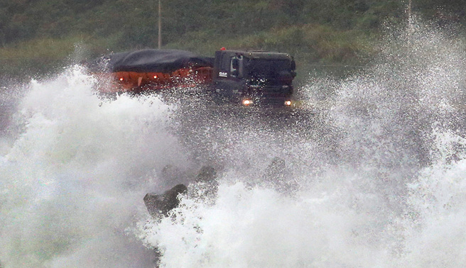 中度颱風小犬4日襲台，中央氣象署已發布海上及陸上颱風警報，在北部濱海公路水湳洞路段大浪直撲岸際，從遠方望去彷彿陸上行舟。（范揚光攝）