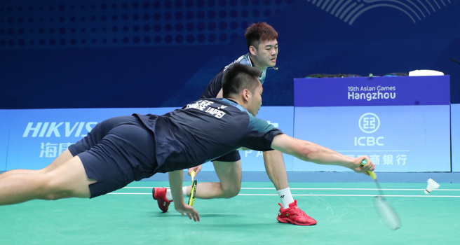 羽球选手李洋（前）鱼跃救球。（郑任南摄）