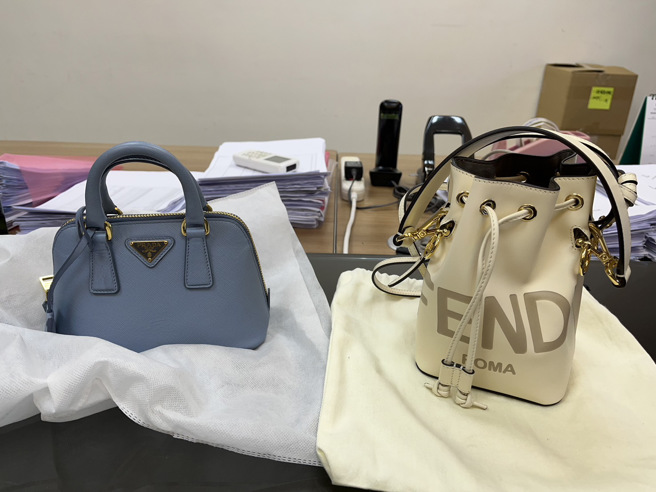 47岁祈姓女子徒手将摆放于店内展示区之PRADA水蓝色侧背包放进随身袋子内，于离开后再趁机窃取FENDI米色水桶包，价值共约12万5千元。（图／警方提供）