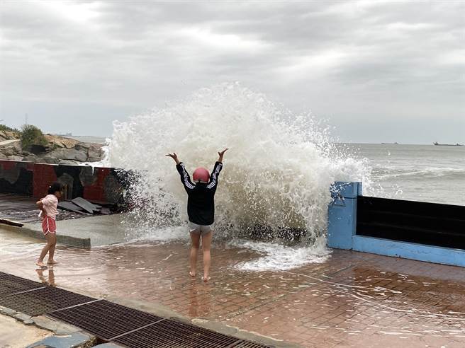 有家长不顾危险放任小孩在岸边戏水，数尺巨浪迎面打来，令人捏把冷汗。(于家麒摄)