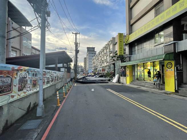 桃园大溪侨爱国小旁，5日下午4时许，小犬颱风强风吹飞社区警卫室铁皮屋顶，占据双向车道。（翻摄照片／蔡明亘桃园传真）