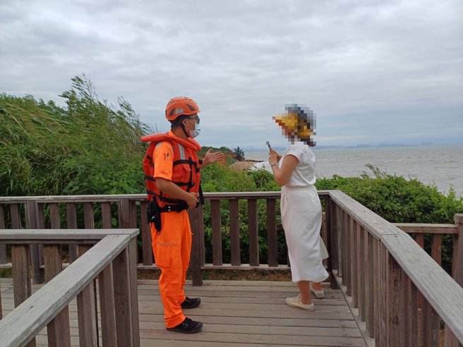 第九岸巡队人员在海边劝说游客勿进入警戒状态内观浪。( 笫九岸巡队提供)