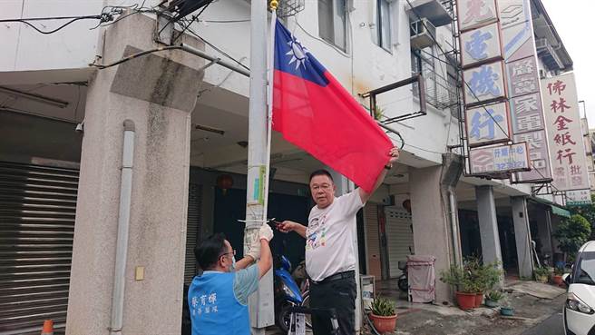 国民党台南市议员蔡育辉6日在新营区街头绑国旗，号召民眾一起挂国旗将爱国付诸行动。（程炳璋摄）